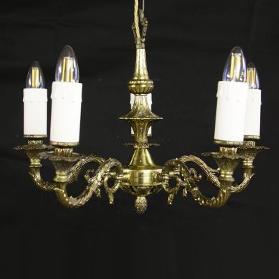 Vintage aged brass chandelier with 5 sweeping arms, supporting candles bulbs  