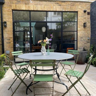 Round zinc topped garden table with painted metal base in a French style