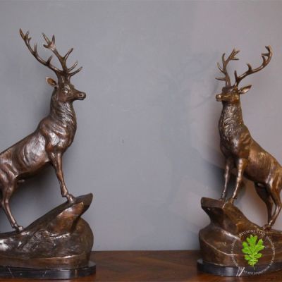 Pair of Bronze Reposing Stags on Marble Plinths